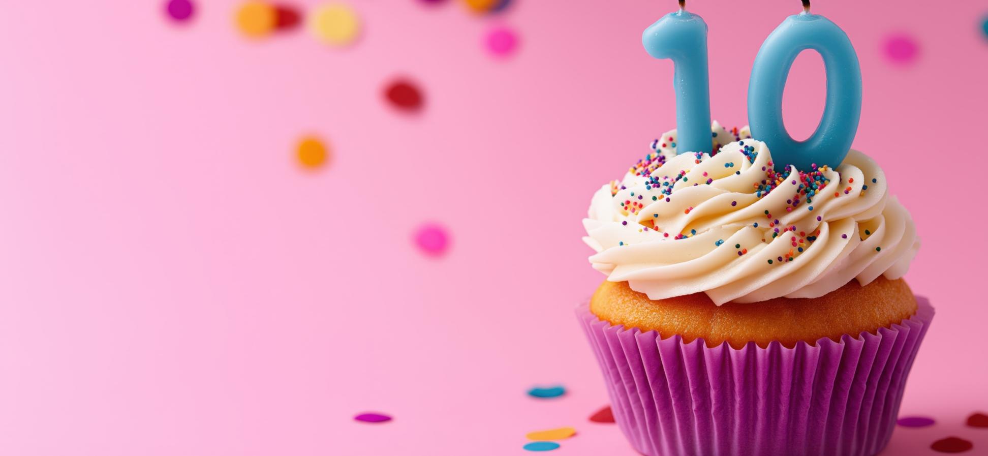 Ein Muffin mit Zahlenkerzen zehn vor rosa Hintergrund