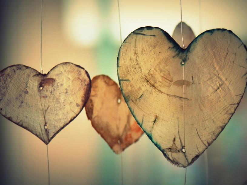 Herzen aus Holz hängen an Schnüren
