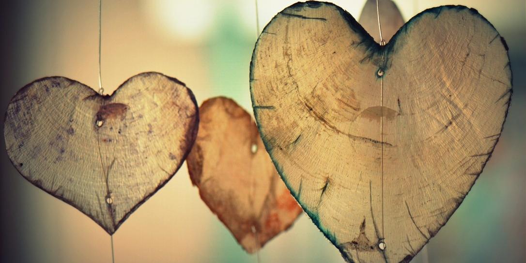 Herzen aus Holz hängen an Schnüren