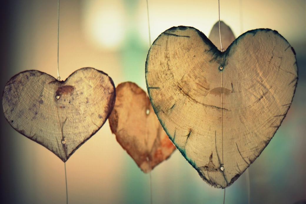 Herzen aus Holz hängen an Schnüren